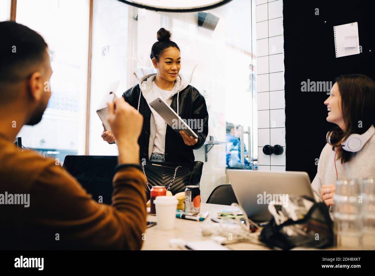 Glückliche junge multi-ethnische Programmierer diskutieren in kleinen kreativen Büro Stockfoto