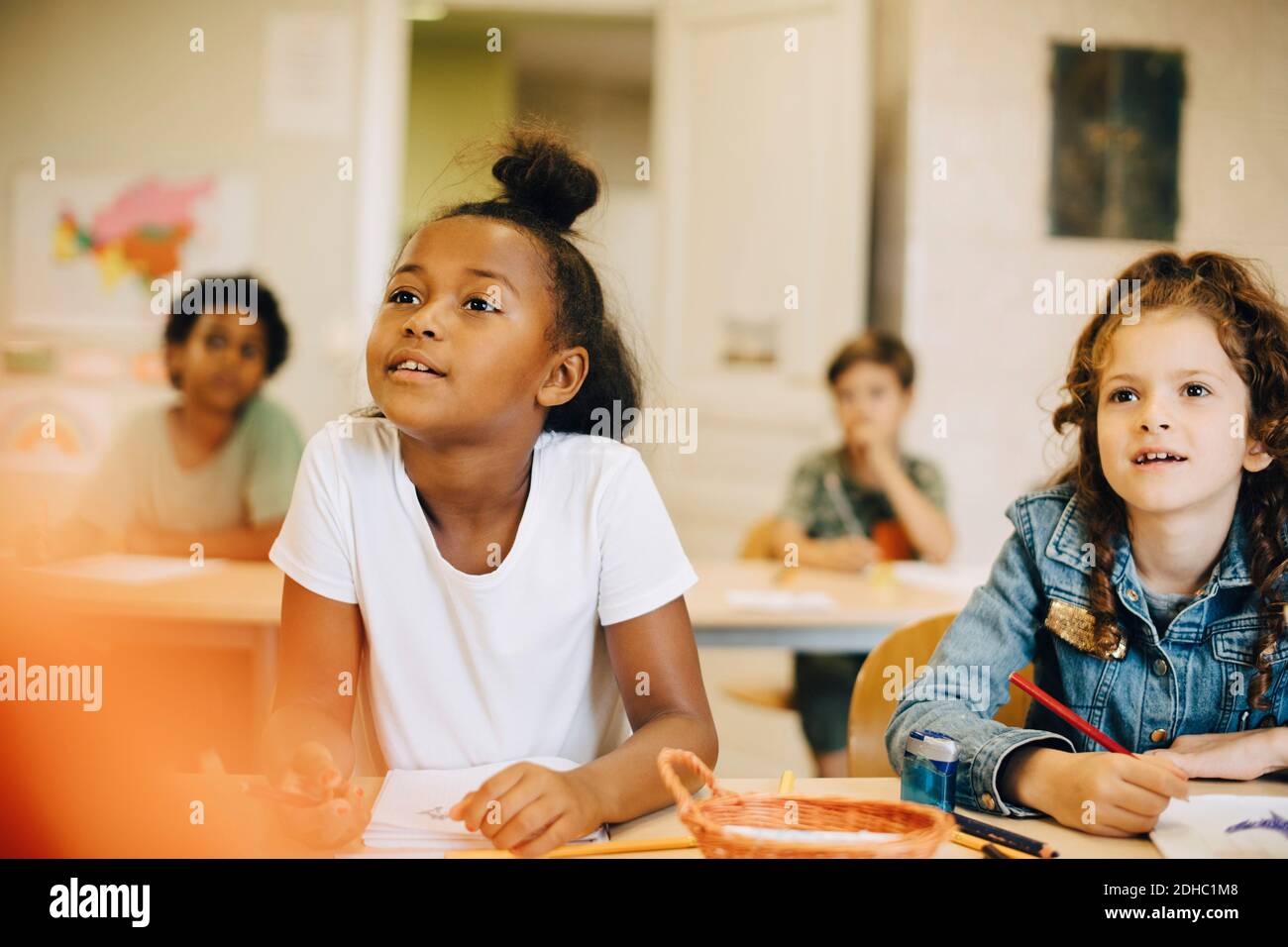 Mädchen lernen am Schreibtisch, während sie im Klassenzimmer sitzen Stockfoto