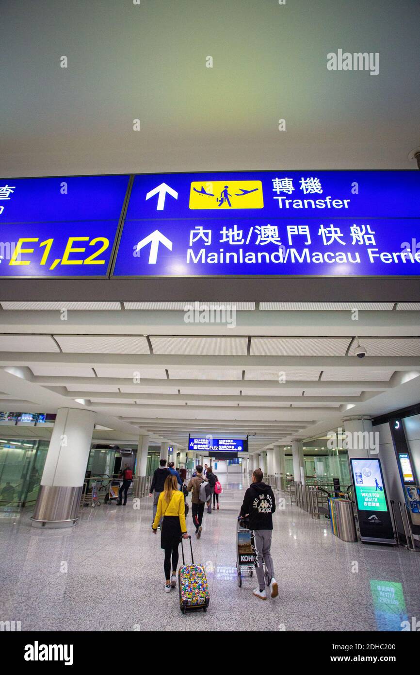 Transfer-Schilder in Hong Kong Flughafen Trolley Passagiere und Gepäck Stockfoto
