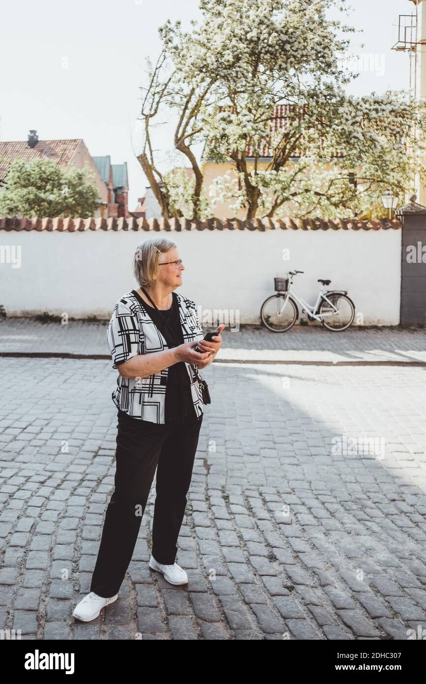 Volle Länge der älteren weiblichen Touristen auf der Straße in Stadt Stockfoto