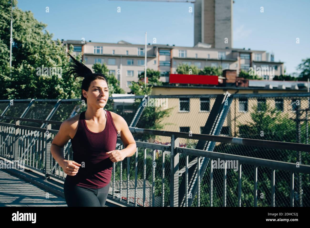 Selbstbewusste Sportlerin beim Joggen auf der Brücke in der Stadt Stockfoto