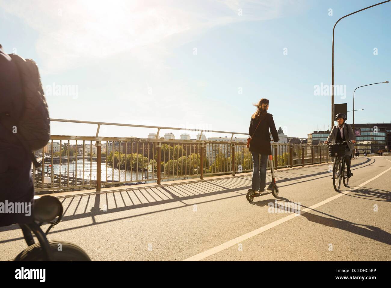 Pendler fahren Elektrofahrzeuge auf Brücke gegen blauen Himmel Stockfoto Pendler fahren Elektrofahrzeuge auf Brücke gegen blauen Himmel Stockfoto