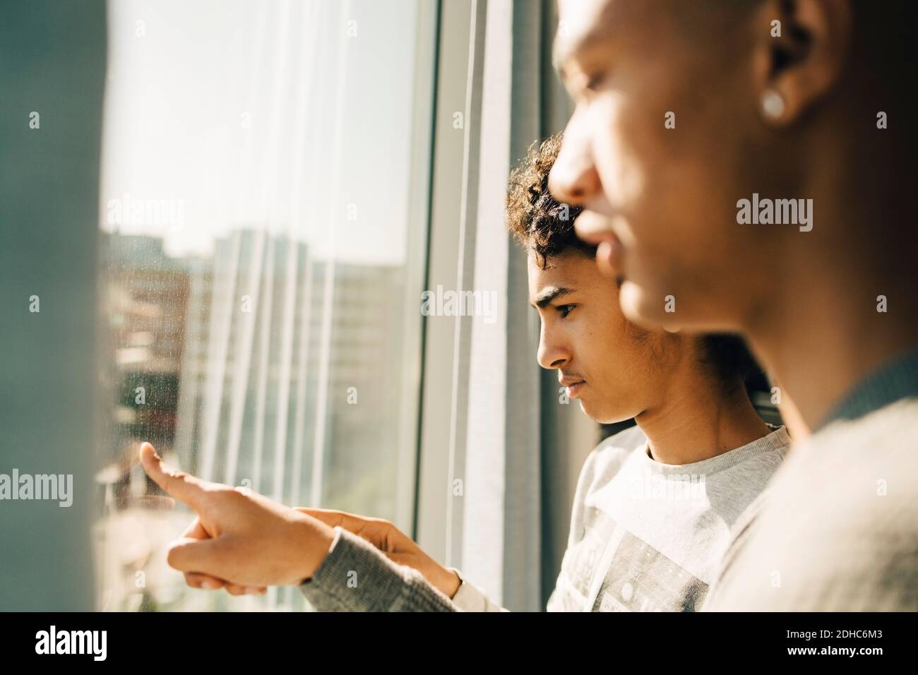 Nachdenkliche Freunde, die durch das Fenster im Restaurant schauen Stockfoto