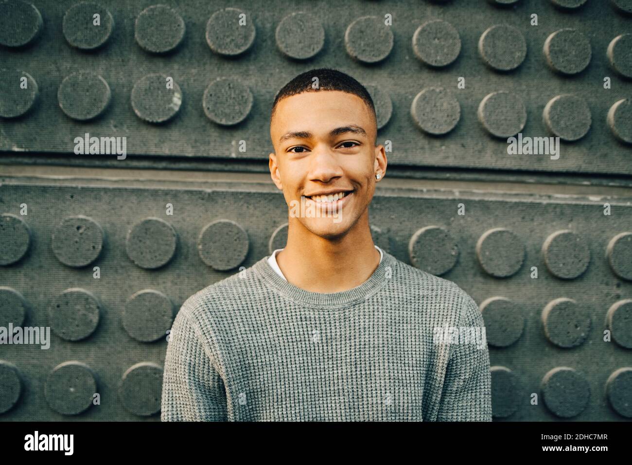 Porträt eines lächelnden Jungen im Teenageralter gegen die Wand Stockfoto