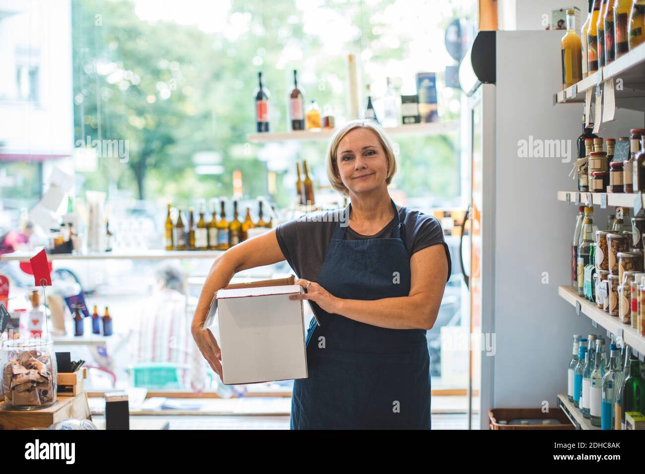 Portrait von selbstbewussten weiblichen Besitzer mit Karton im Deli Stockfoto