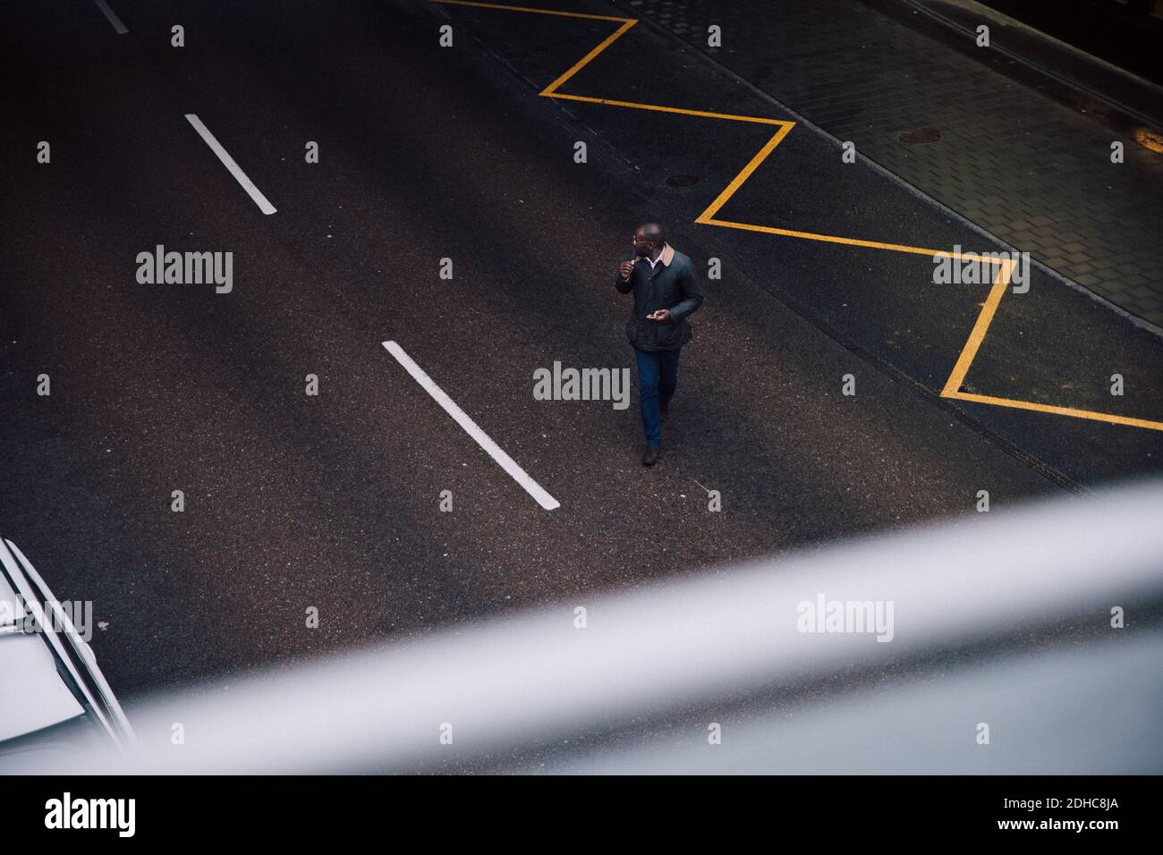Blick auf Geschäftsmann mit Mobiltelefon während des Spazierens Auf der Straße in der Stadt Stockfoto