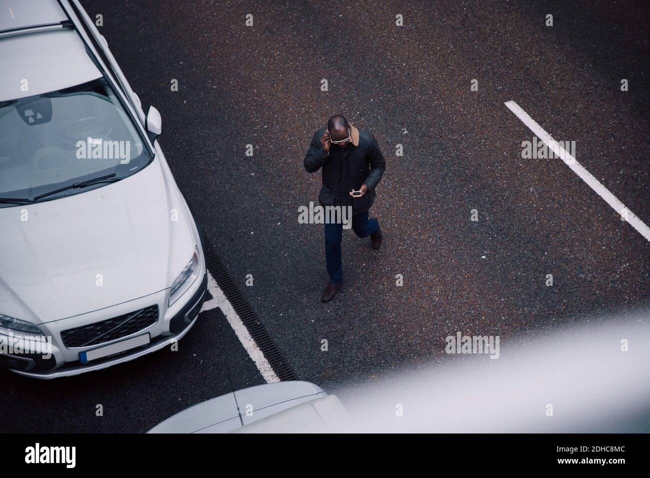 Blick auf Geschäftsmann mit Mobiltelefon während des Spazierens Auf der Straße in der Stadt Stockfoto