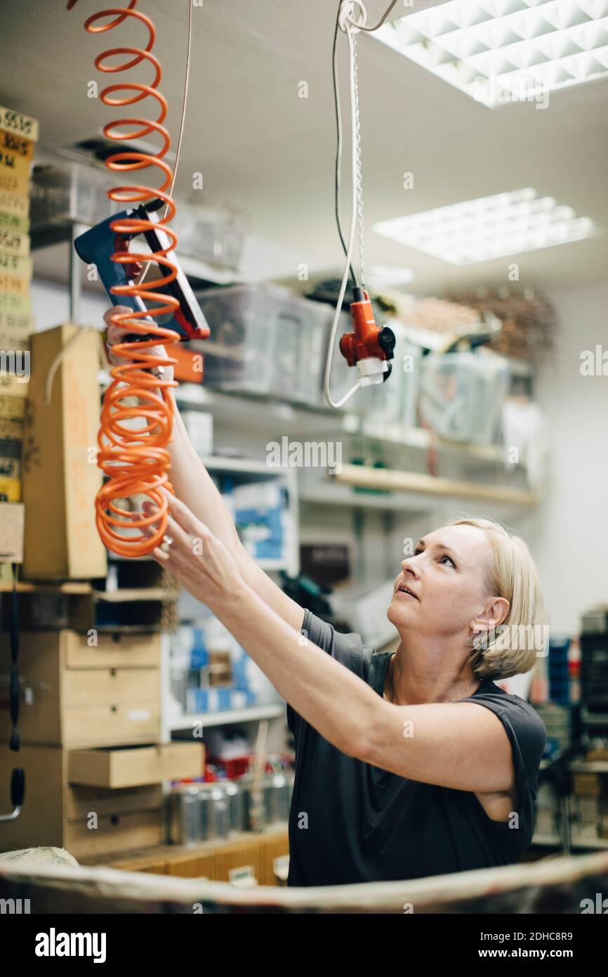 Weibliche Polstermaschine mit Stapelpistole in der Werkstatt Stockfoto