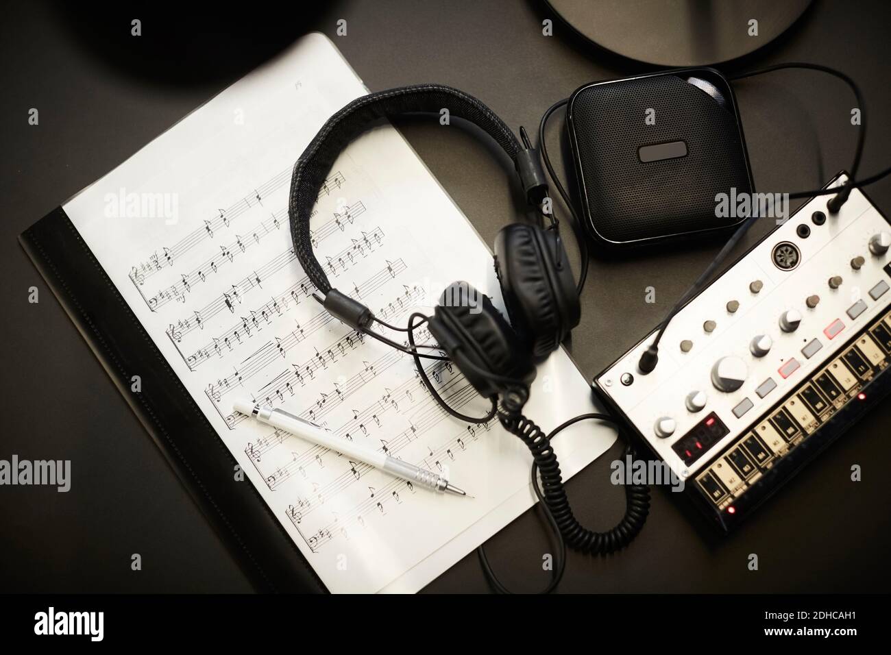 Direkt über Aufnahme von Kopfhörern auf Noten mit Ton Ausstattung am Schreibtisch im Büro Stockfoto