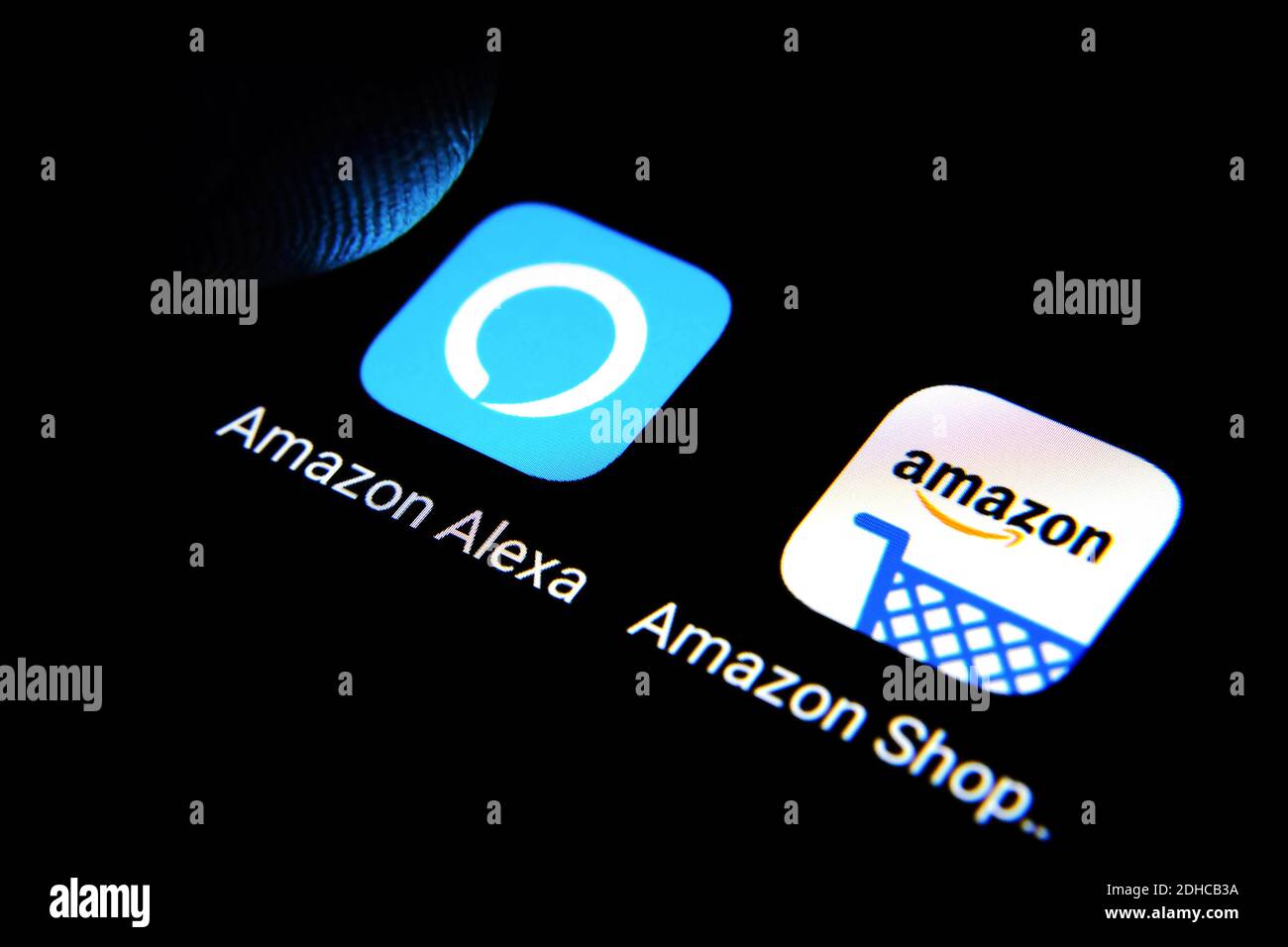 Amazon Alexa und Amazon Shopping Apps werden auf dem Smartphone-Bildschirm angezeigt ein Finger berührt den Bildschirm Stockfoto