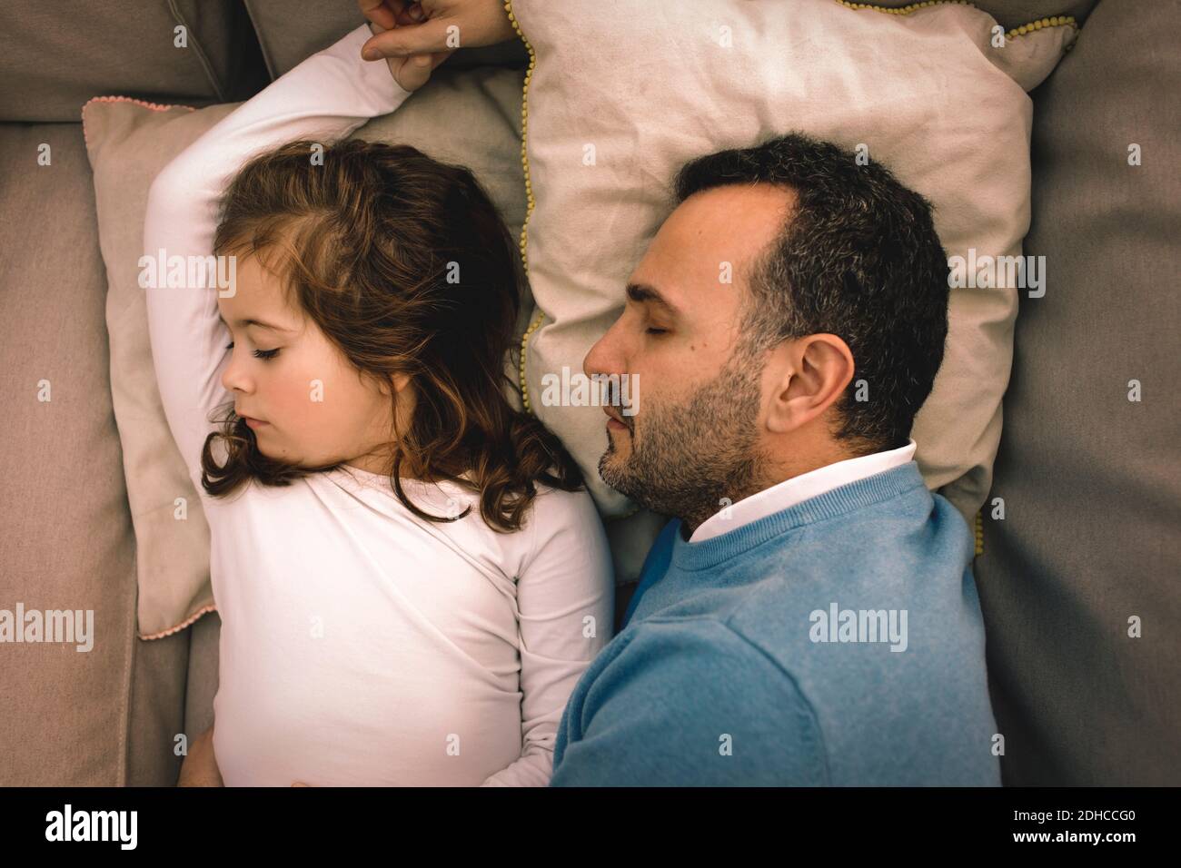 Direkt oben Aufnahme von Vater und Tochter, die auf der Couch schlafen Zu Hause Stockfoto