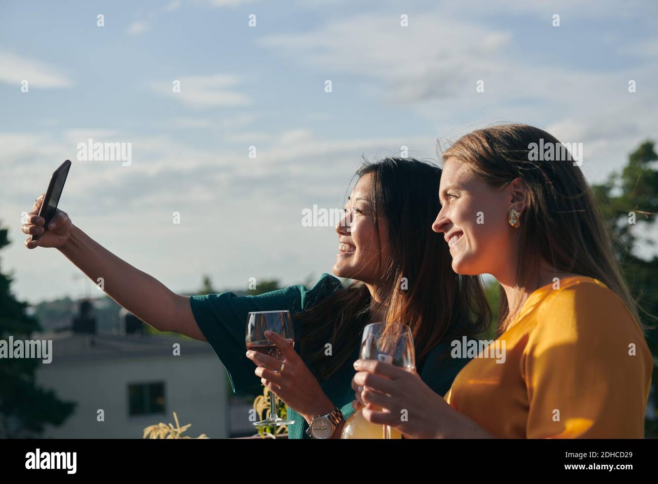Fröhliche Freundinnen machen Selfie mit Handy auf der Terrasse An sonnigen Tagen Stockfoto