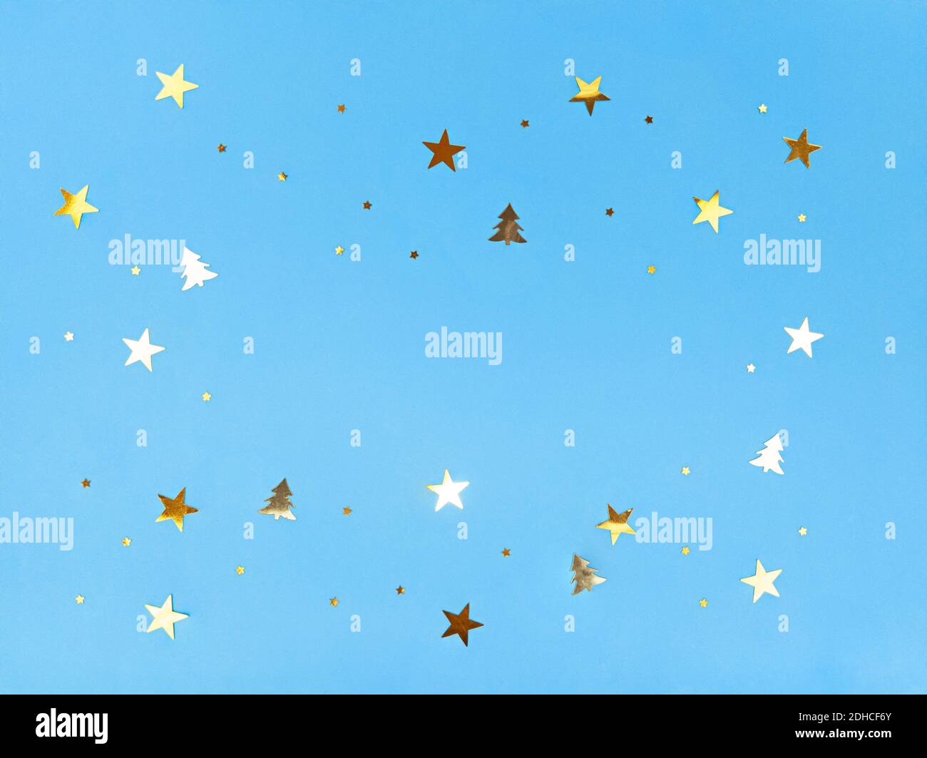 Konfetti Sterne und Bäume funkeln auf blauem Hintergrund. Stockfoto