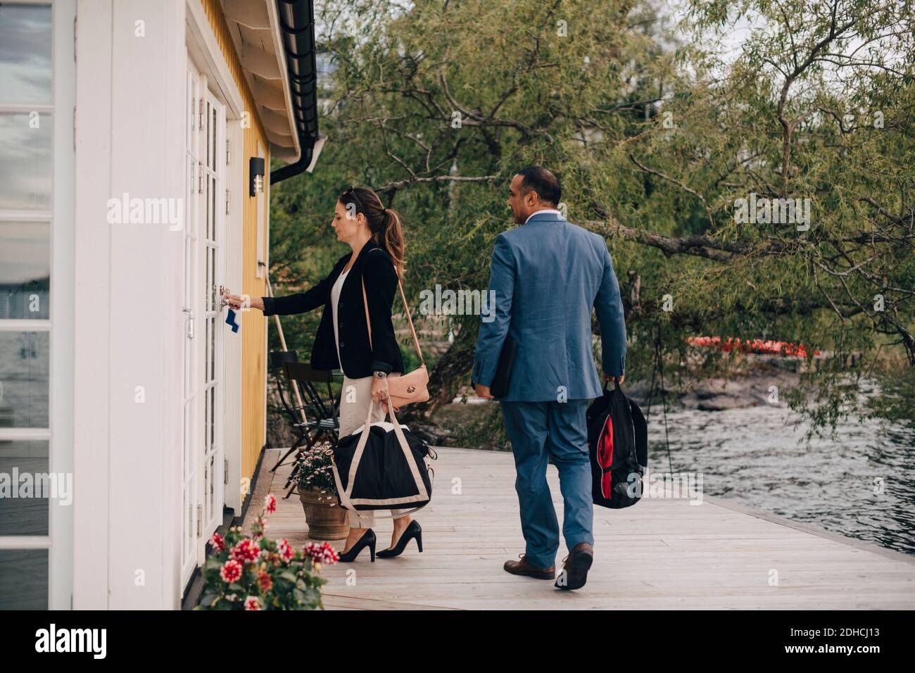 Volle Länge des reifen Paares Entriegelungstür in der Ferienvilla Am See Stockfoto