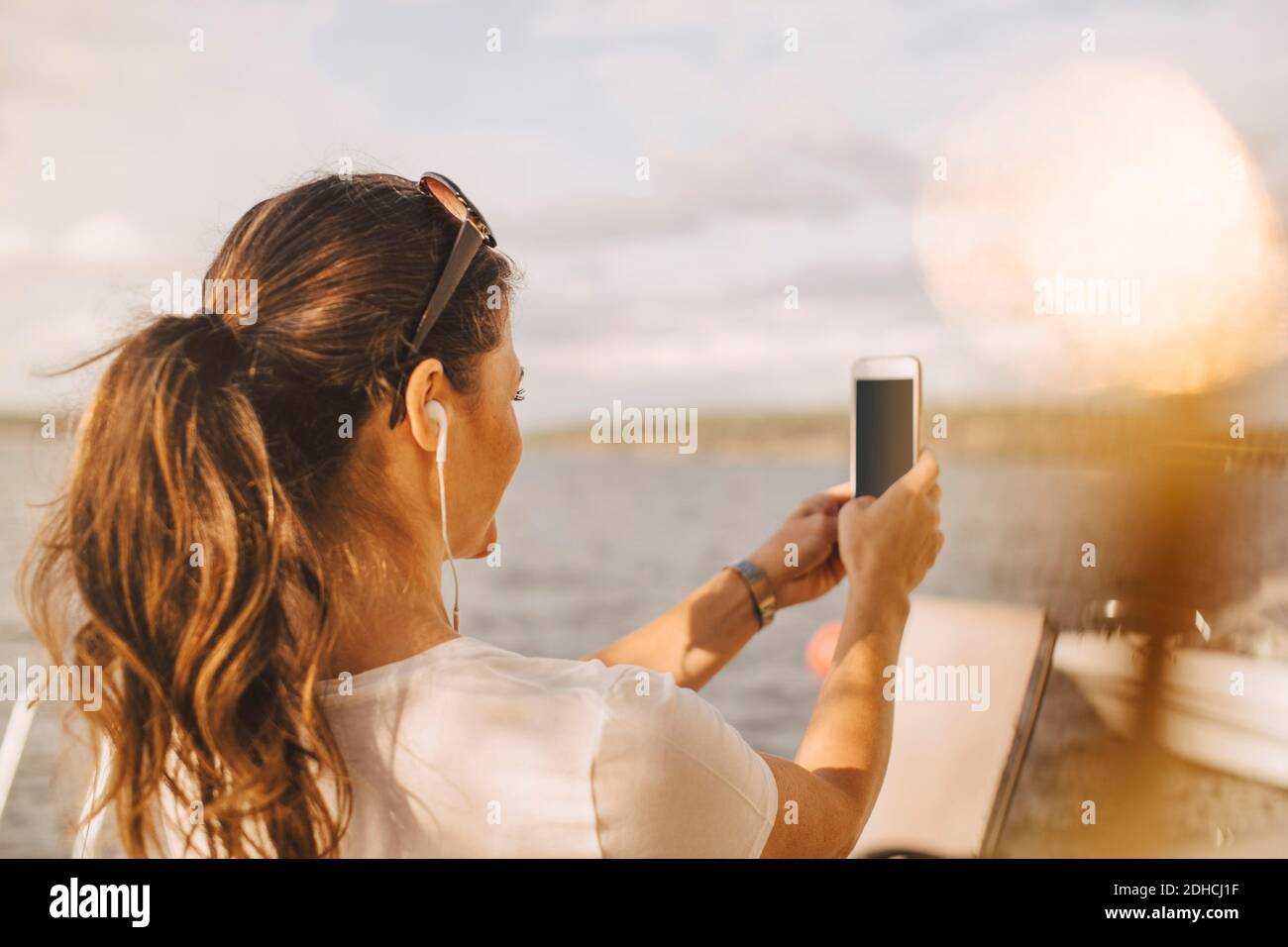 Frau nimmt Selfie durch Handy gegen See im Sommer Urlaub Stockfoto