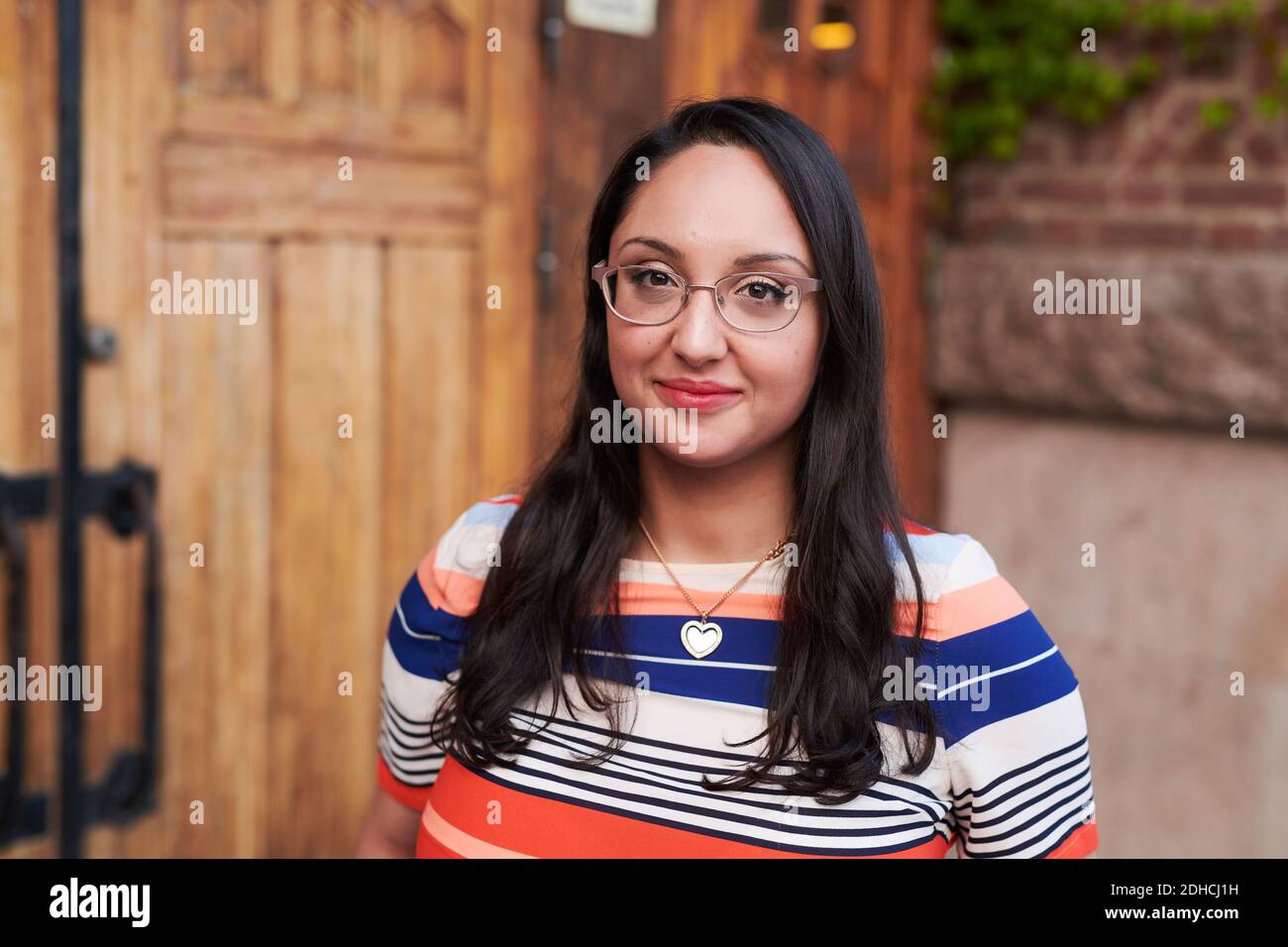 Porträt einer jungen Frau mit Brille außerhalb der Sprachschule Stockfoto