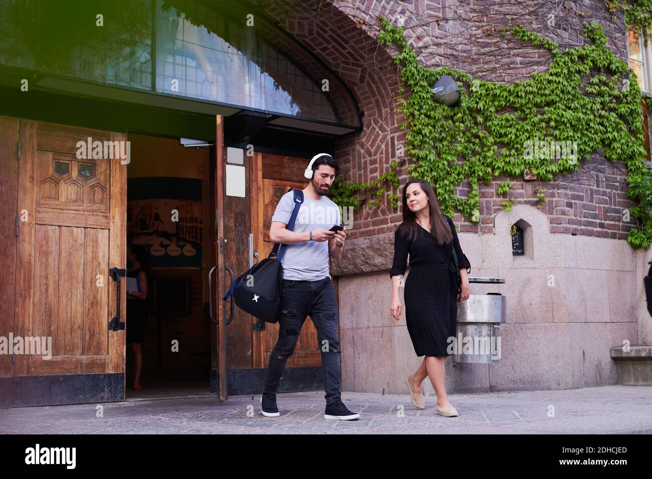 Volle Länge von mittleren Erwachsenen männlichen und weiblichen Freunden zu Fuß Außerhalb der Sprachschule Stockfoto