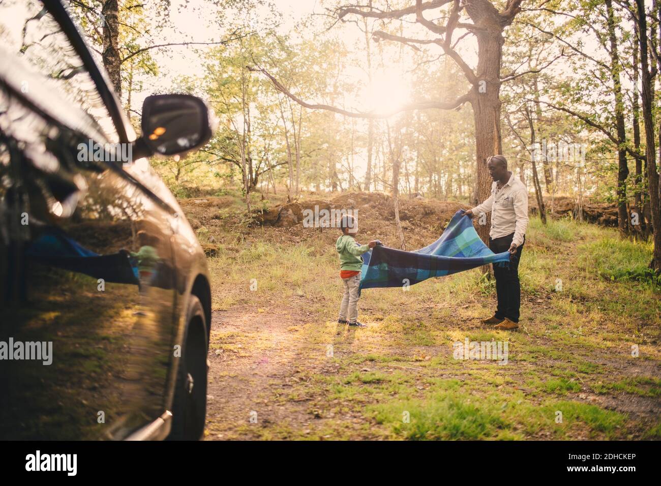 Volle Länge von Vater und Sohn halten Picknick Decke an parken Stockfoto