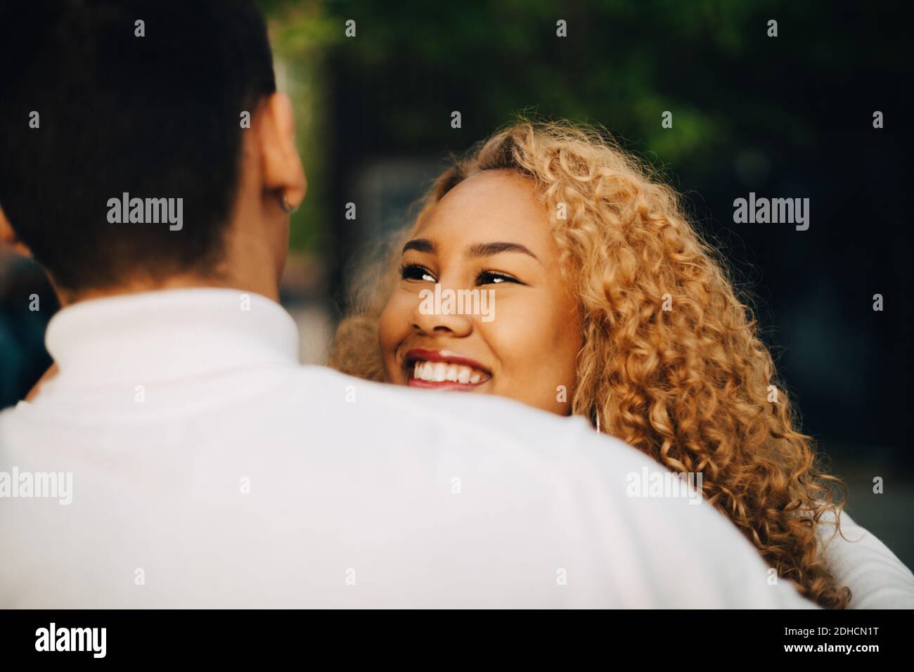 Nahaufnahme einer lächelnden Frau, die einen Freund im Freien ansieht Stockfoto