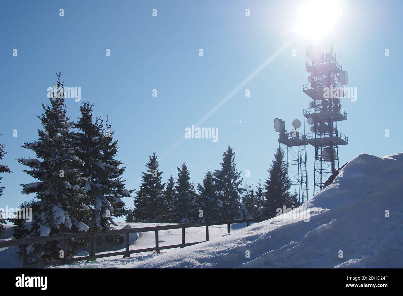 Kommunikationsturm mit Mikrowellenrelais-Geschirr auf dem Schoeckl in Österreich im Winter. Die Bäume und der Boden sind mit Schnee bedeckt. Stockfoto