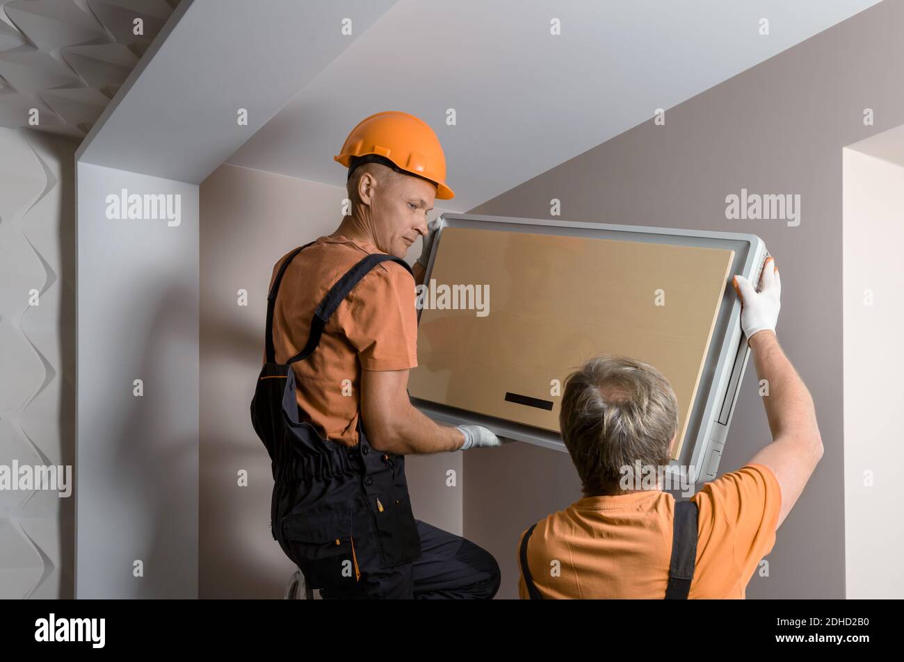 Arbeiter installieren ein Split-System für eine Klimaanlage zu Hause. Stockfoto