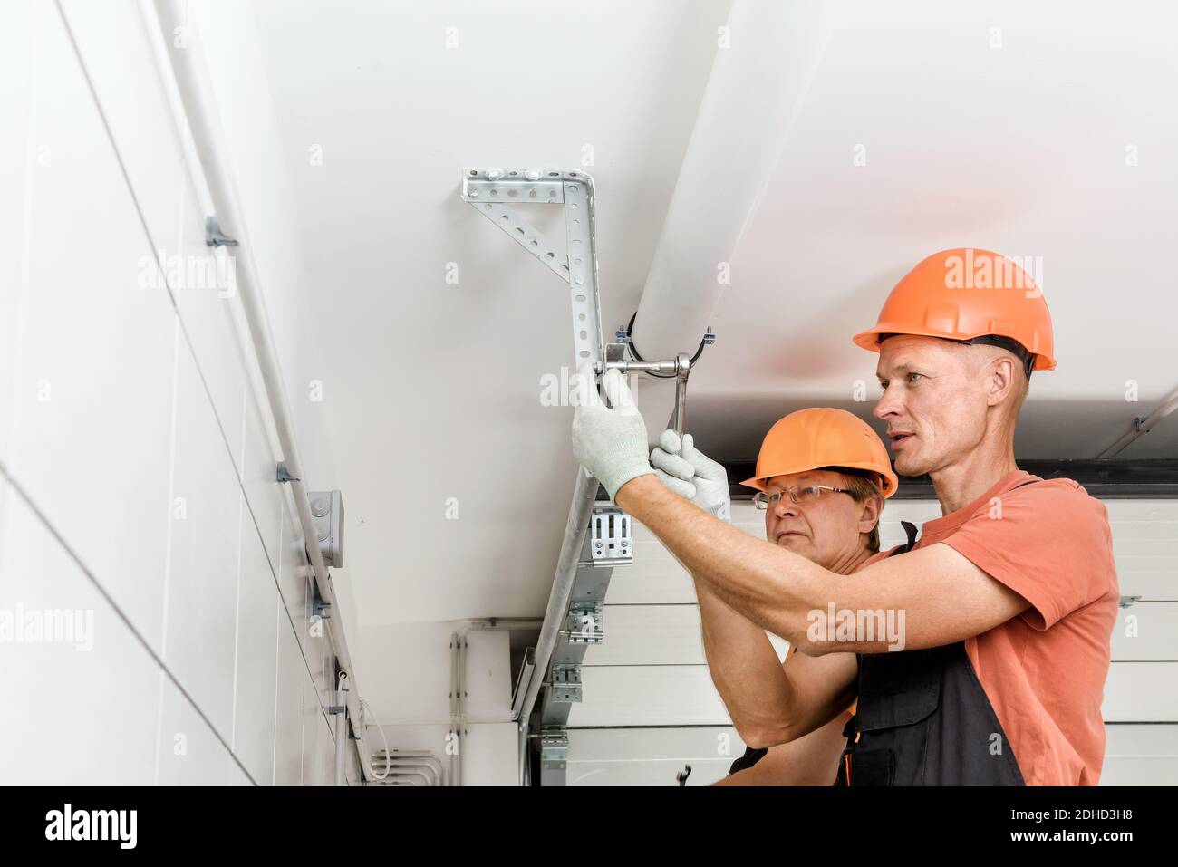 Die Arbeiter installieren in der Garage Hubtore. Stockfoto