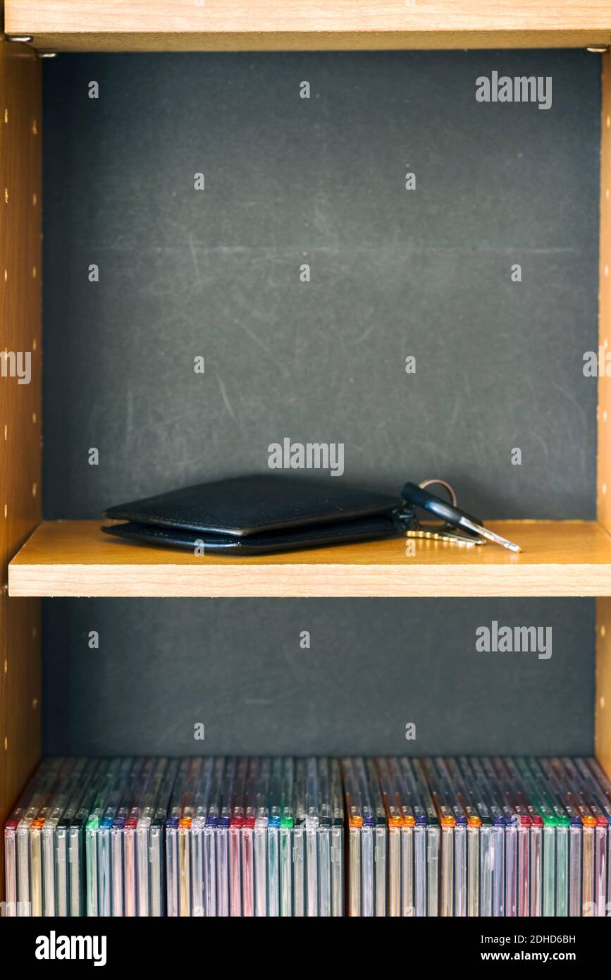 Eine Brieftasche und Schlüssel liegen auf einem hölzernen Medienturm. Stockfoto