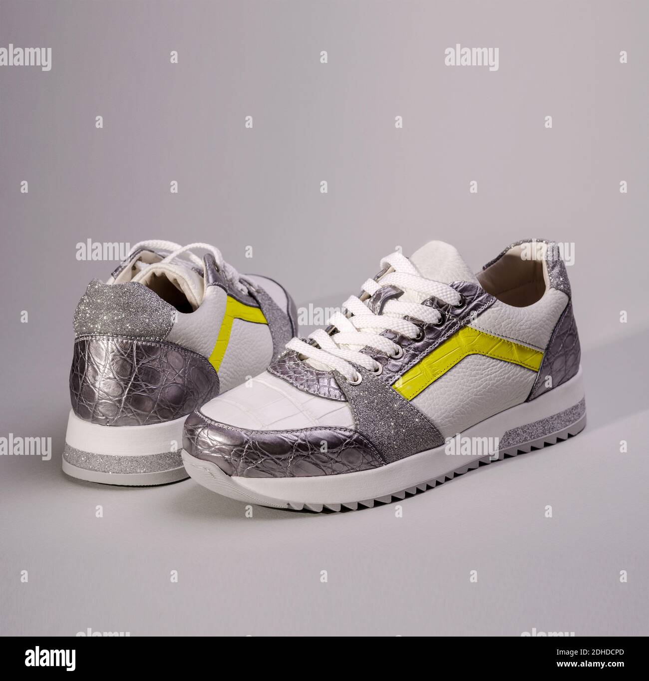 Zwei Fashion Sneakers Schuhe in ultimativen grauen und leuchtenden gelben  Farben des Jahres 2021. Modische Damen-Sportschuhe Stockfotografie - Alamy