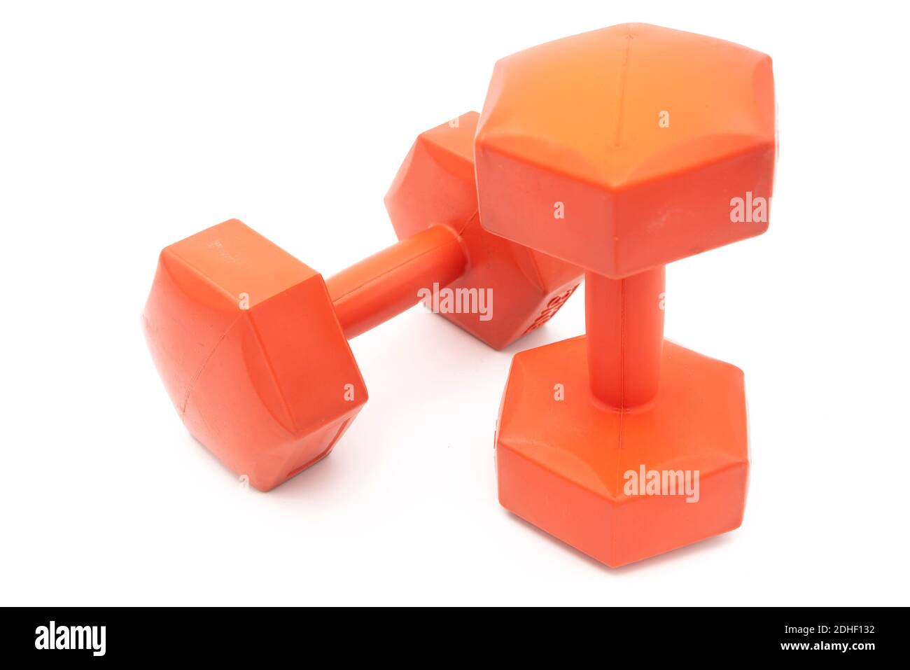 Zwei mit Kunststoff überzogene orangene Hanteln schneiden isoliert auf Weiß aus Hintergrund Stockfoto