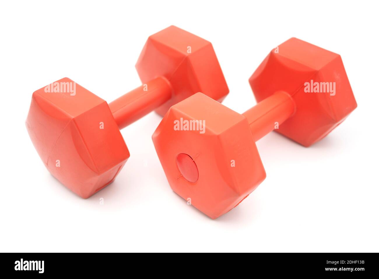 Zwei mit Kunststoff überzogene orangene Hanteln schneiden isoliert auf Weiß aus Hintergrund Stockfoto