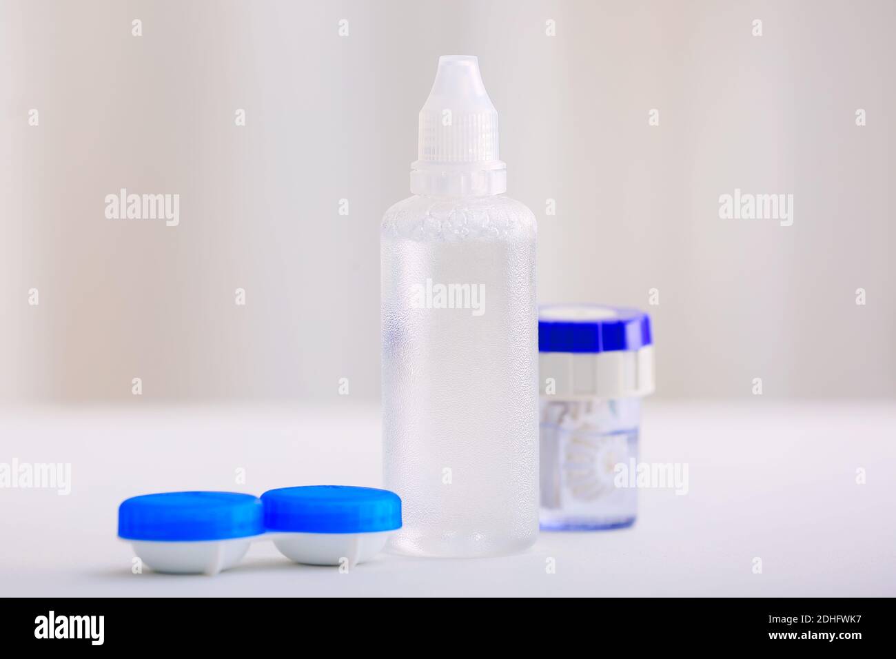 Behälter mit Kontaktlinsen und Lösung auf verschwommenem Hintergrund Stockfoto