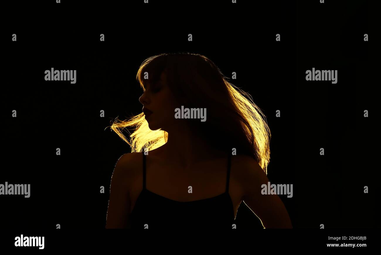 Silhouette der schönen jungen Frau auf dunklem Hintergrund Stockfoto