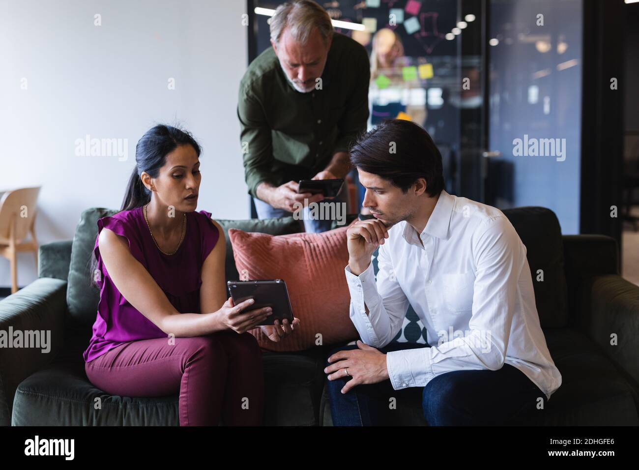 Diverse Geschäftsmann und Geschäftsfrau tragen mit elektronischen Geräten im Büro Stockfoto