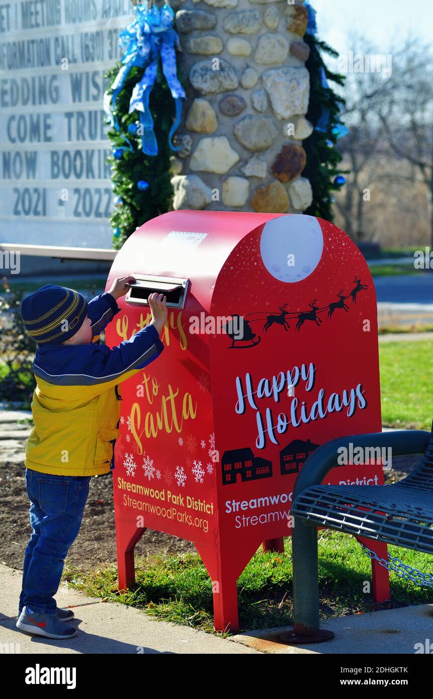 Streamwood, Illinois, USA. Kleiner Junge, der seinen Brief an den Weihnachtsmann (Vater Weihnachten) an eine spezielle Mailbox von einem Gemeindepark Bezirk zur Verfügung gestellt. Stockfoto