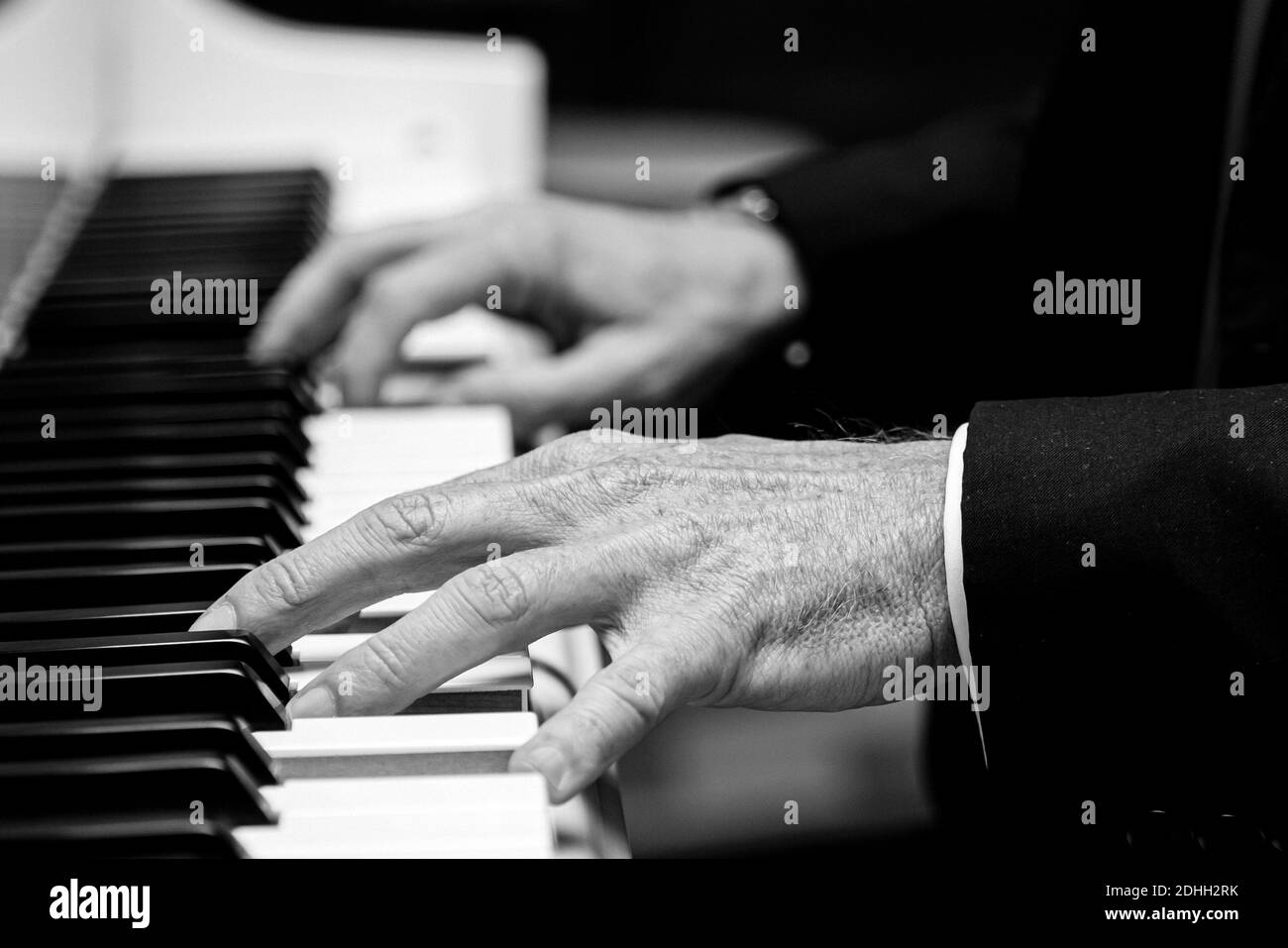 Eine Graustufenaufnahme von alten Händen, die Klavier spielen Stockfoto