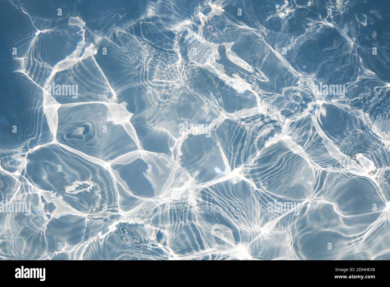 Blaue Wasserschwimmfläche mit hellen Sonnenlichtreflexionen. Für Hintergrund Stockfoto