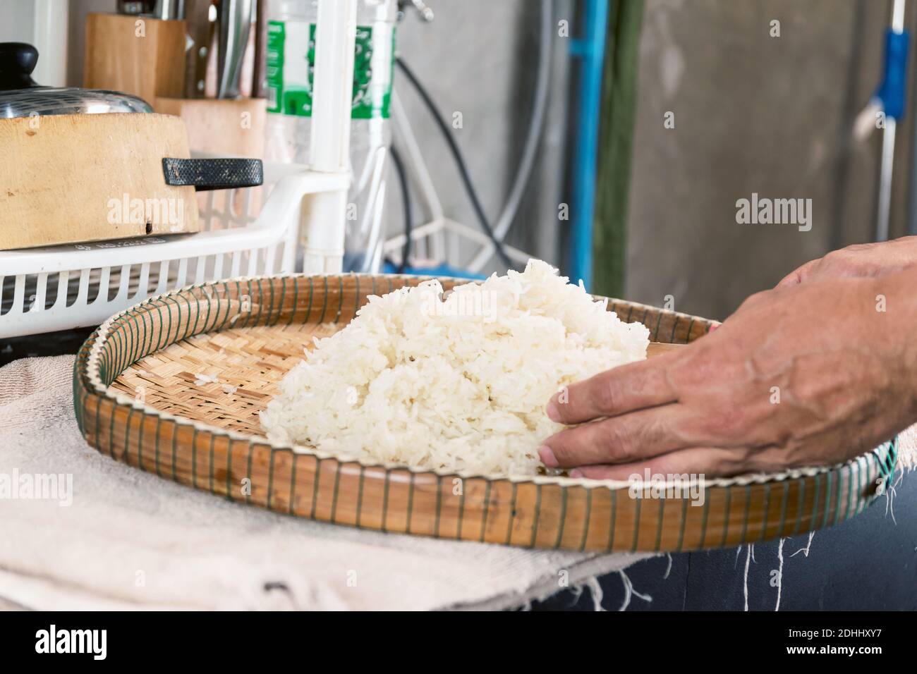 Stellen Sie den gedämpften Klebreis auf ein Bambusblech, damit sich die Hitze ausbreiten kann. Stockfoto