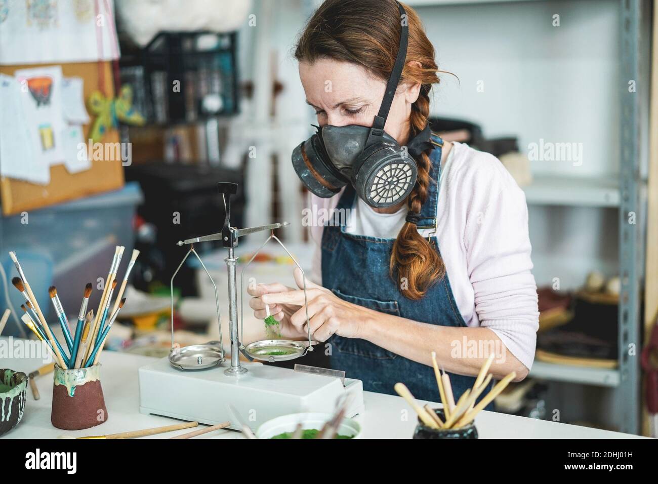 Kaukasische Frau Mischen Malfarben mit einem Vintage-Balance im Inneren Ihr kreatives Töpferstudio - Fokus auf ihr Auge Stockfoto