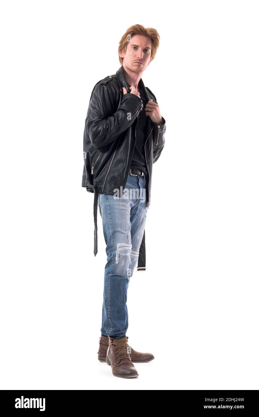 Seitenansicht des selbstbewussten jungen Mannes in Jeans und Stiefeln Anpassung schwarze Lederjacke. Ganzkörperlänge isoliert auf weißem Hintergrund. Stockfoto