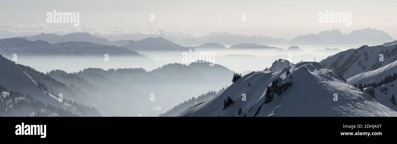 Snow Mountains Panorama im tief liegenden Inversionsnebel. Silhouetten von Nebelbergen. Landschaftlich schöne verschneite Winterlandschaft. Blick von Stuiben nach Saentis Stockfoto