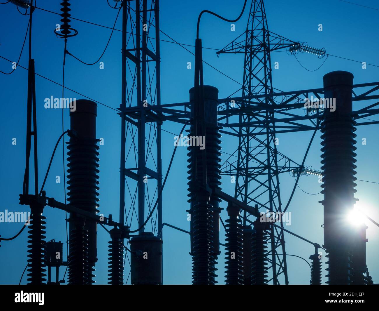 Silhouette in einem blauen skye von Isolatoren und Hochspannung Pylone einer Elektrostation Stockfoto
