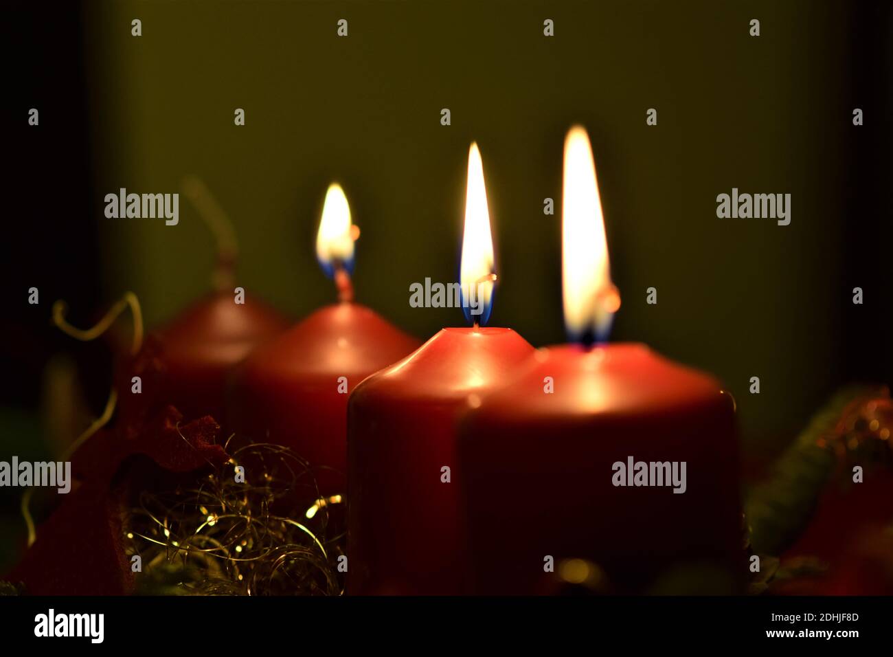 Nahaufnahme eines Adventsarrangements mit drei brennenden Kerzen Stockfoto