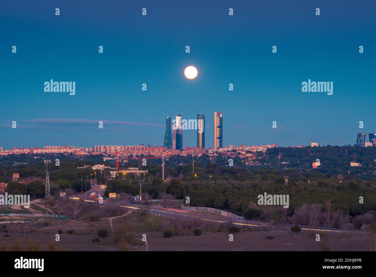 Ruhiger Blick auf Madrid mit den Skylines des Cuatro Torres Business Bereich unter Himmel mit hellen Mond am Abend Stockfoto