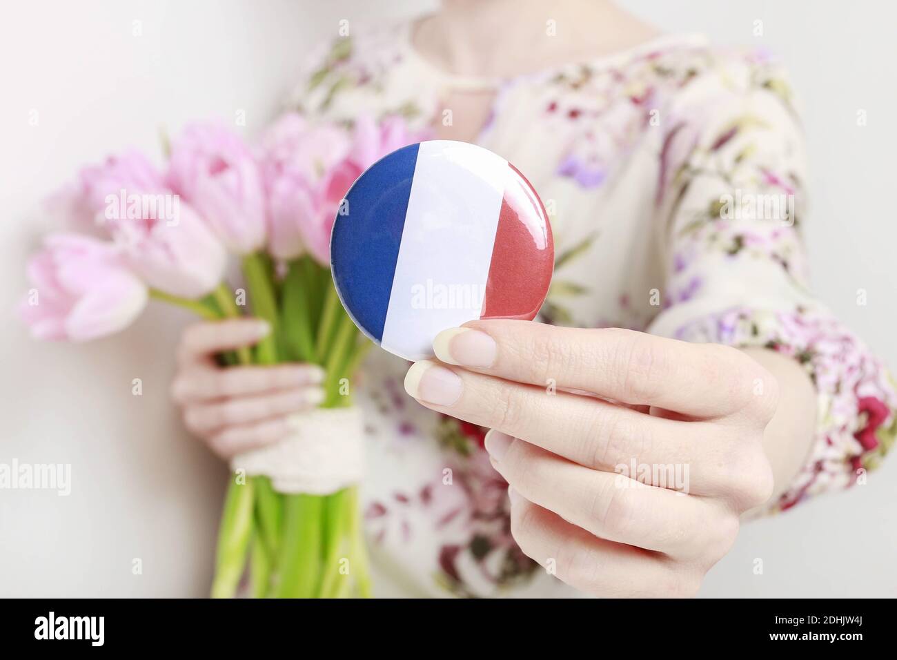 Flagge von Frankreich auf Knopf Abzeichen gedruckt, hält von Frau in ihren schönen Händen. Stockfoto