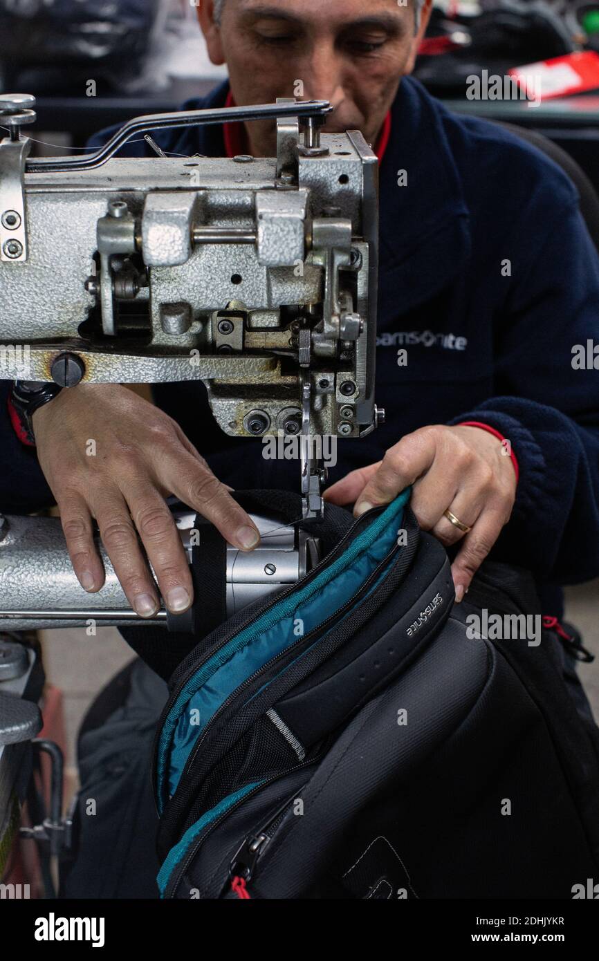 Männliche Arbeiter repariert Gepäck mit Nähmaschine in der Werkstatt in Santiago, Chile Stockfoto