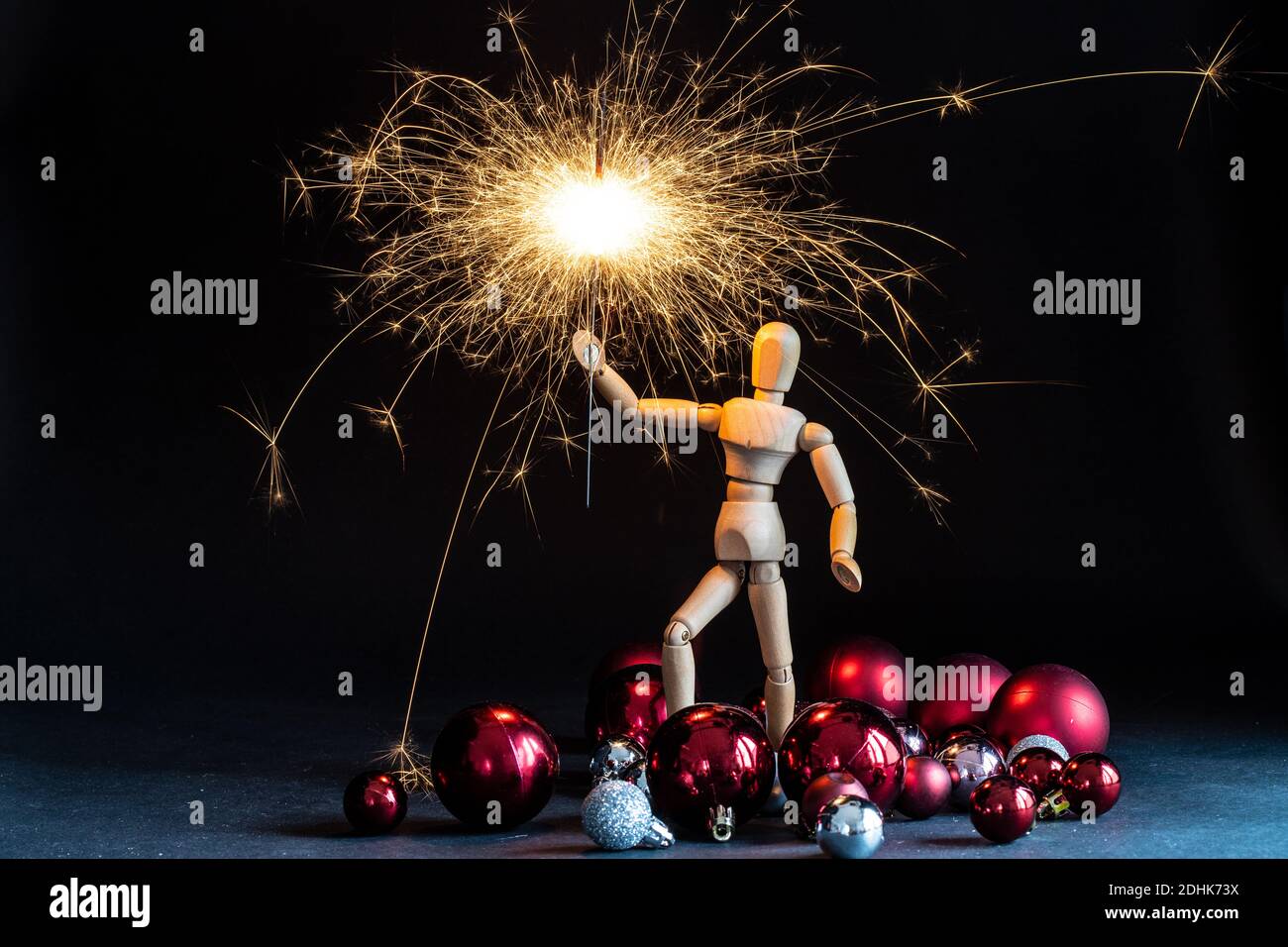 Holzfigur mit weihnachtskugeln und Wunderkerze Stockfoto