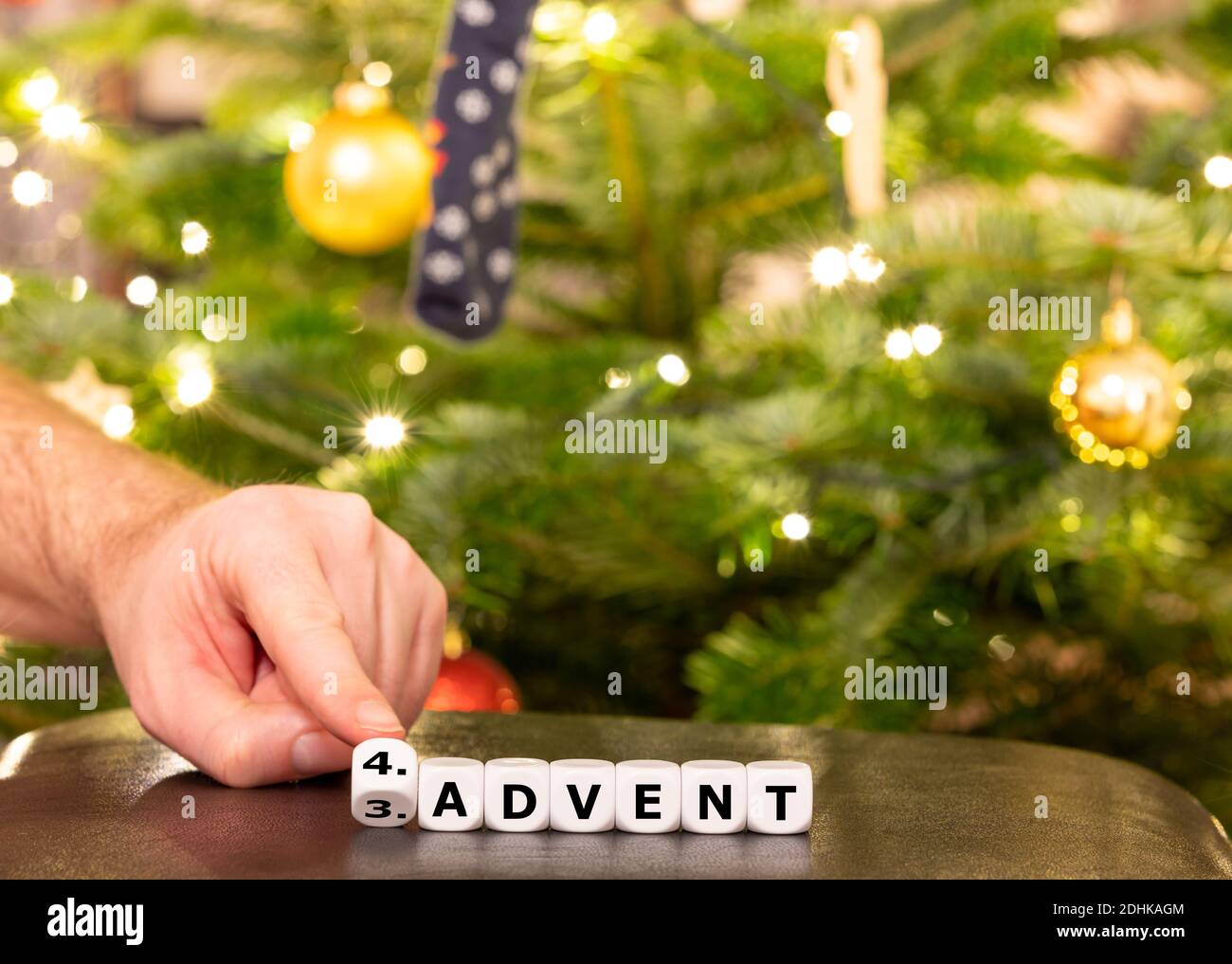 Hand dreht Würfel und ändert den deutschen Ausdruck '3. Advent' (3. Advent) bis '4. Advent' (4. Advent). Stockfoto