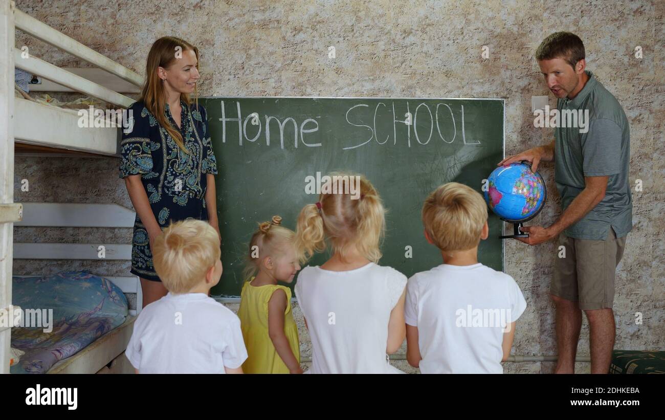 Home School-Konzept. Eltern lehren ihre Kinder mit einem Globus in der Hand. Stockfoto