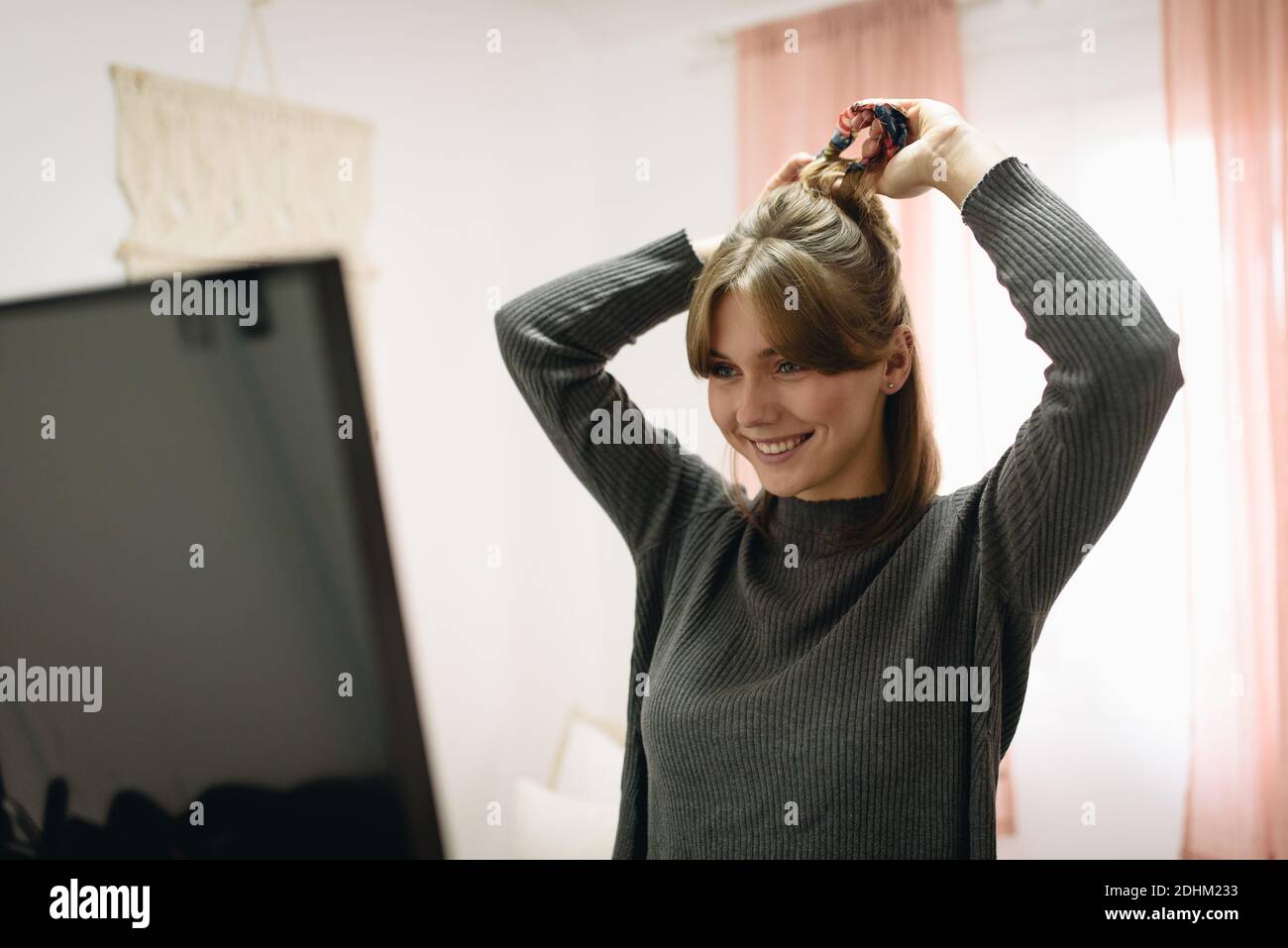 Blonde Mädchen kämmen ihre Haare vor einem Spiegel Stockfoto