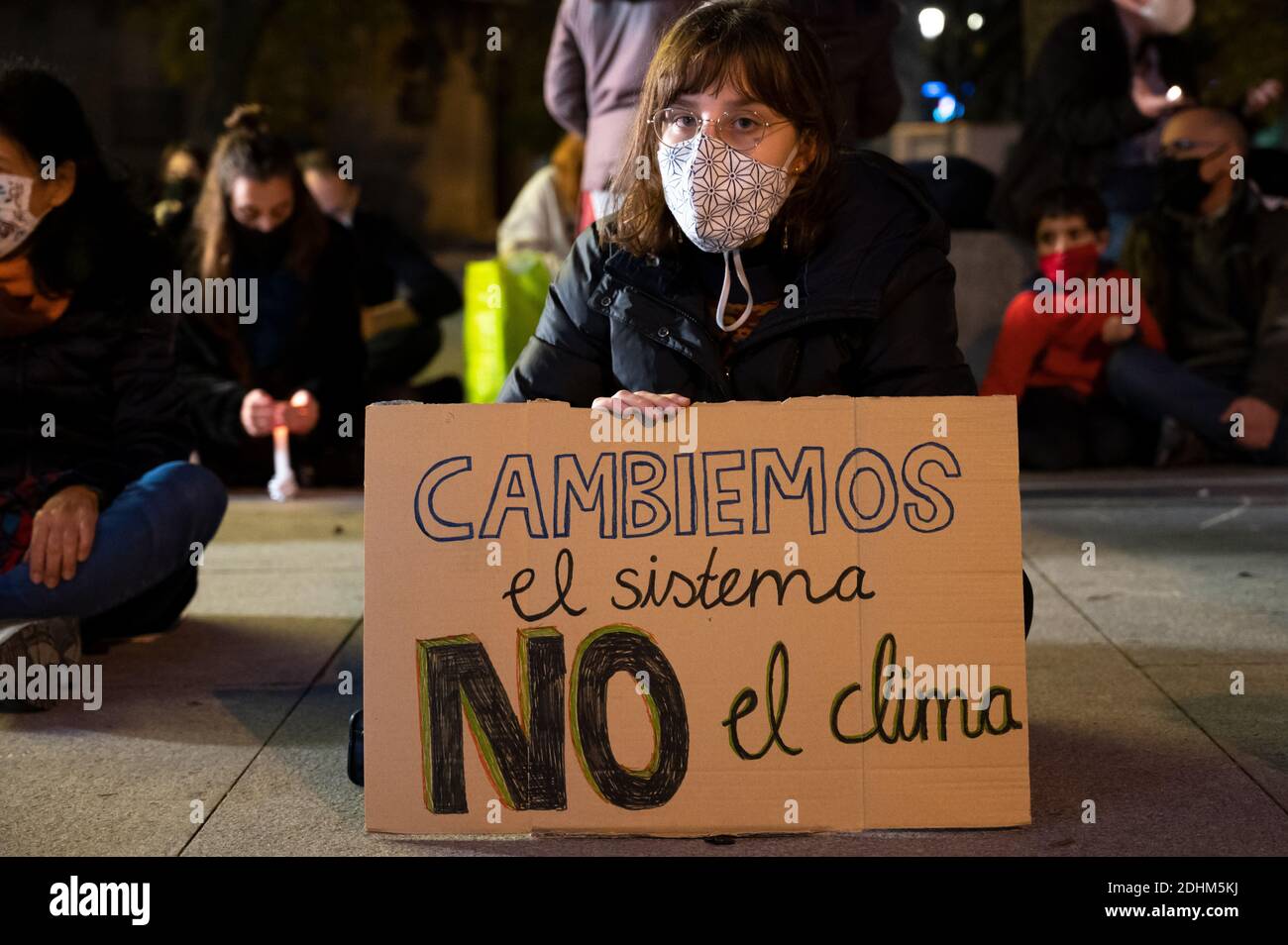 Madrid, Spanien. Dezember 2020. Klimaaktivistin mit einem Plakat mit der Aufschrift "Let's change the System, not the Climate" während eines Protestes vor dem spanischen Parlament, der zum Handeln aufruft, seit es fünf Jahre nach dem Pariser Klimaabkommen ist und die globale Temperatur steigt. Quelle: Marcos del Mazo/Alamy Live News Stockfoto